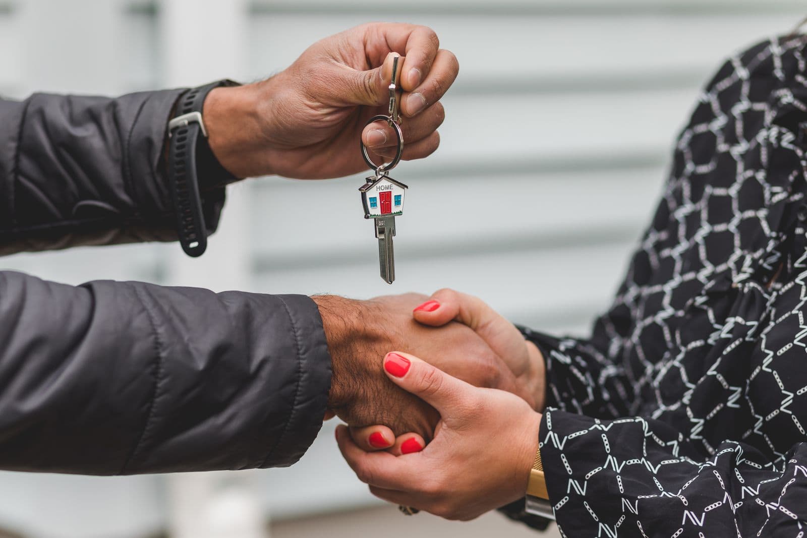Real estate agent handing over house keys after closing a deal