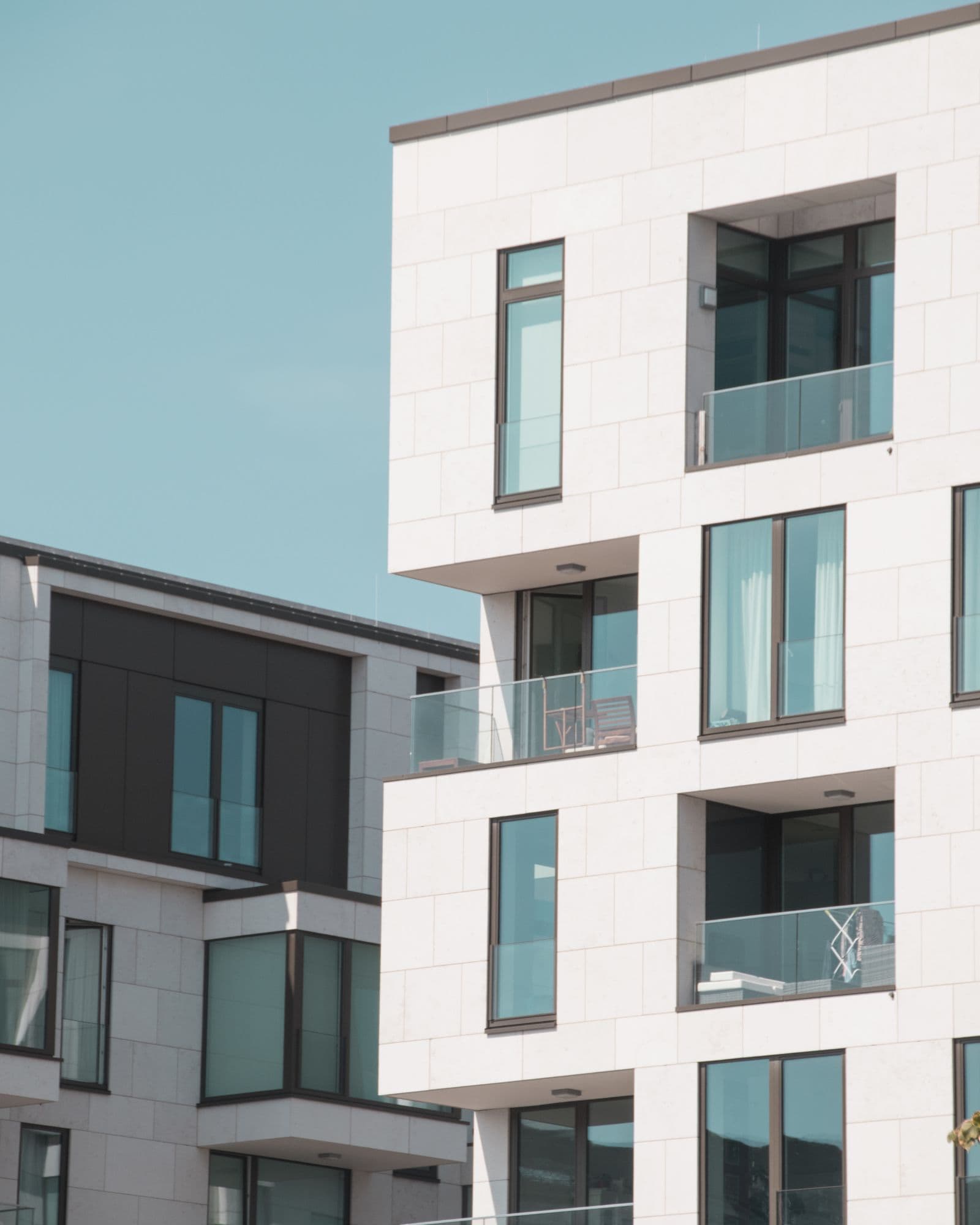 Modern apartment building facade with balconies under blue sky